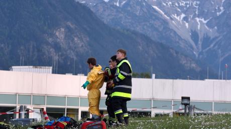 Einsatzkräfte der Feuerwehr stehen vor der abgeriegelten Notaufnahme des Unfallklinikums Murnau.