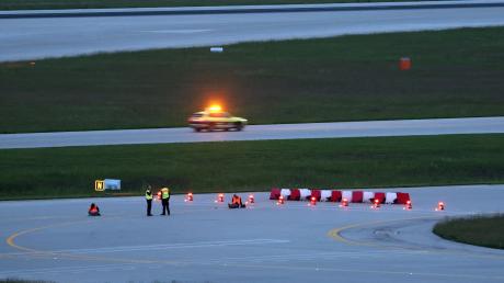 Klimaaktivisten haben sich am frühen Morgen auf einer Zufahrt für Start- und Landebahnen am Flughafen Franz-Josef-Strauß festgeklebt.