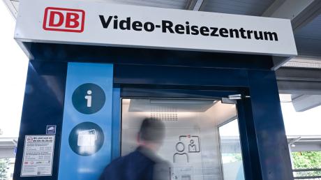 Eine Person geht in ein Video Reisezentrum an einem Regionalbahnhof (gestellte Szene).