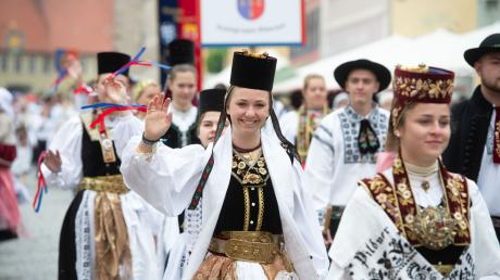 In traditioneller Tracht laufen Teilnehmer eines Trachtenumzuges der Siebenbürger Sachsen durch die Altstadt von Greding.