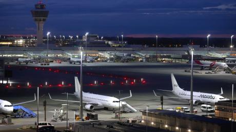 Flugzeuge stehen vor Sonnenaufgang auf dem Flughafen Franz-Josef-Strauß.