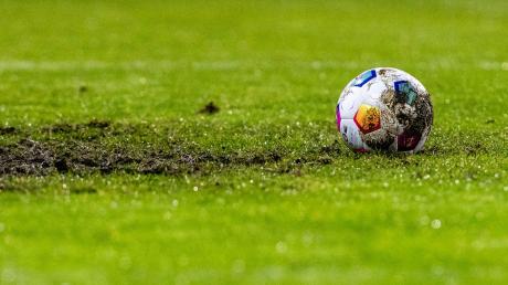Ein Fußball liegt auf dem Rasen eines Fußballfelds.