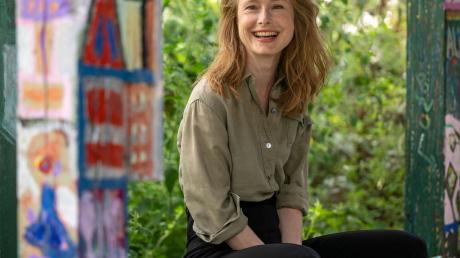 Schauspielerin Odine Johne sitzt bei einem Porträttermin in einem Garten in Neukölln.