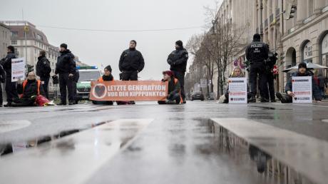 Mitglieder der Umweltschutz-Gruppe «Letzte Generation» blockieren eine Kreuzung auf der Straße «Unter den Linden».