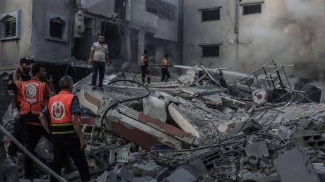 Palästinensische Rettungskräfte inspizieren die Trümmer nach einem israelischen Angriff.