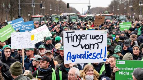 Auf der Demo des Deutschen Bauernverbandes hält jemand ein Schild "Finger weg vom Agrardiesel" hoch.
