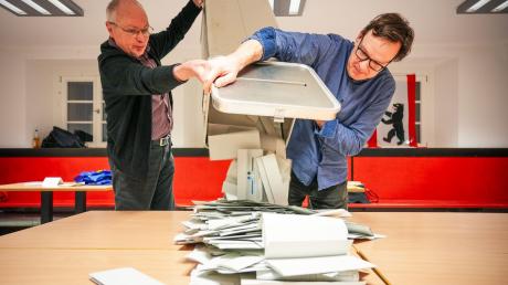Wahlhelfer leeren bei der Stimmauszählung im Carl von Ossietzky-Gymnasium im Wahllokal 317 die Wahlurnen aus.
