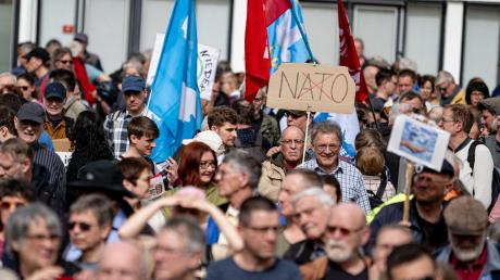 Ein Pappschild mit dem durchgestrichenen Wort "Nato" ist auf dem traditionellen Ostermarsch unter dem Motto «Kriegstüchtig - Nie wieder» zu sehen.