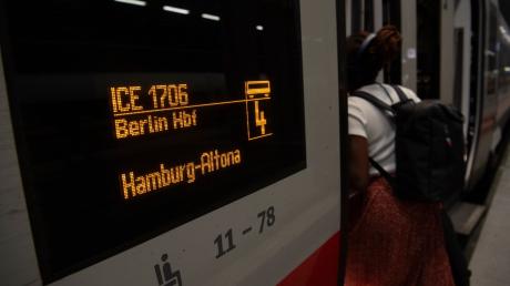 Eine Frau steigt im Hauptbahnhof Berlin in einen Zug nach Altona.