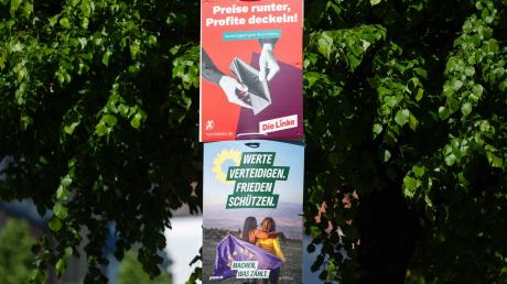 An einer Straßenlaterne hängen Wahlplakate für die Europawahl am 9. Juni.