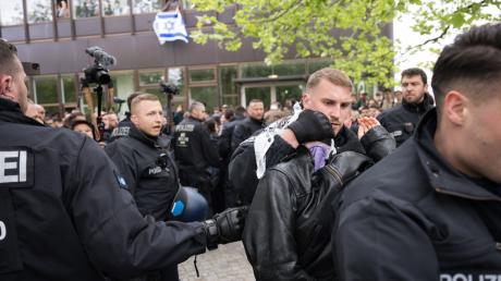 Polizeibeamte bringen während einer propalästinensischen Demonstration der Gruppe «Student Coalition Berlin» auf dem Theaterhof der Freien Universität Berlin außerhalb des Camps Demonstranten weg. Die Teilnehmer haben am Dienstagvormittag den Platz mit Zelten besetzt.