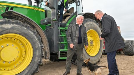 Bundespräsident Frank-Walter Steinmeier (M) und Dietmar Woidke (r, SPD), Ministerpräsident von Brandenburg, stehen bei Benjamin Meise, Landwirt eines Agrarbetriebs, auf einem Acker.