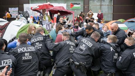 Polizeibeamte gehen während propalästinensischen Demonstration der Gruppe «Student Coalition Berlin» auf dem Theaterhof der Freien Universität Berlin gegen Demonstranten vor.