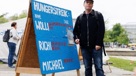 Der Klimaaktivist Adrian Lack vom Bündnis «Hungern bis ihr ehrlich seid» steht neben einer Tafel mit der Liste der Anzahl von Hungerstreik-Tagen.