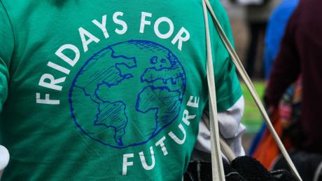 Eine Frau demonstriert in einem grünen T-Shirt mit der Aufschrift «Friday for Future».