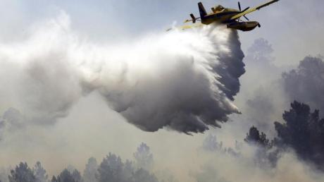 Ein Löschflugzeug verteilt im portugiesischen Vila Velha de Rodao entlang des Tajo eine Ladung Wasser. Fast 2000 Feuerwehrleute sind bei sechs großen Waldbränden im Einsatz.