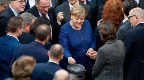 Bundeskanzlerin Angela Merkel gibt bei der Sitzung des Bundestages ihre Stimmkarte bei der namentlichen Abstimmung über neue Organspende-Regeln ab.