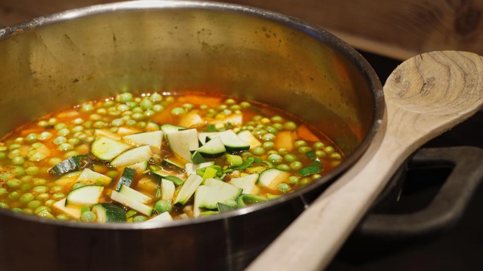 After 15 minutes, add the peas and pumpkin to the soup and simmer for another 15 minutes.