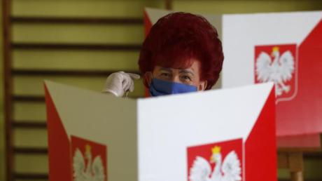 Mit Mundschutz, aber frisch toupiert: Eine Wählerin bei der Stimmabgabe in  Rybnik. Polen entscheidet in einer Stichwahl über den Präsidenten.