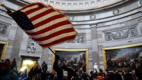 Ein Demonstrant schwenkt die US-Flagge im Inneren des US-Kapitols, nachdem Anhänger von US-Präsident Donald Trump das Gebäude gestürmt hatten.