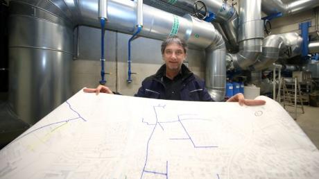 Geschäftsführer Markus Hertel steht mit einem großen Plan des Weißenhorner Fernwärmenetzes im Pumpenhaus beim Müllheizkraftwerk.  