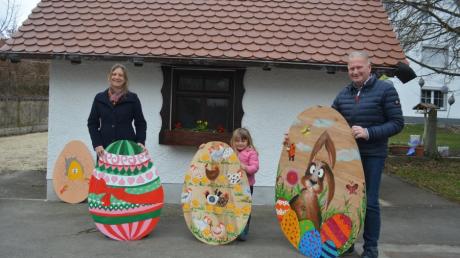Die Vereinsgemeinschaft Wullenstetten organisiert eine Ostereiersuche. Auf dem Bild sind Andrea Zosel (links), Josef Ölberger und die vierjährige Magdalena mit drei der von Freiwilligen gestalteten Eiern zu sehen. 