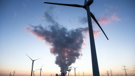 Vorne das dreht sich das Windrad, im Hintergrund arbeitete das Braunkohlekraftwerk. Die EU-Kommission setzt auf erneuerbare Energie, um das Klima zu retten.  