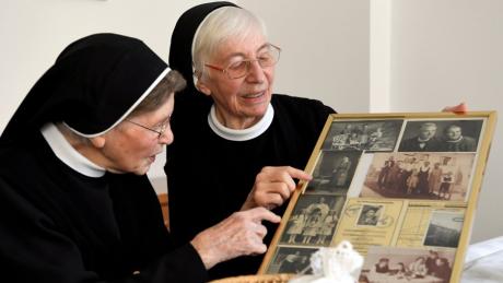 Schwester Edelwina (links) feierte Ende März ihren 100. Geburtstag im Augsburger Kloster Maria Stern. Mit Schwester Esther betrachtet sie eine Collage mit Fotos aus  ihrem Leben.