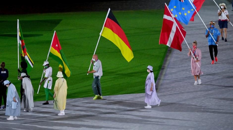 Fahnenträger Ronald Rauhe (mittig) trägt die deutsche Fahne durch das Stadion.