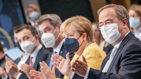 Armin Laschet (rechts), Kanzlerkandidat der Union, sitzt neben Bundeskanzlerin Angela Merkel (CDU) und Markus Söder beim zentralen Wahlkampfauftakt von CDU und CSU. 