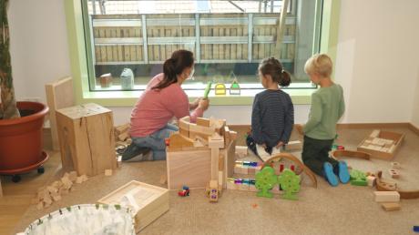 Am Montag startete der Betrieb im Neubau des Rehlinger Kindergartens. Diese zwei Kinder und eine Betreuerin können vom Fenster des Gruppenraums die Fassadenmonteure beobachten.