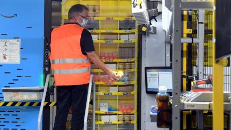 Im Logistikzentrum von Amazon in Graben helfen jetzt Hunderte Transport-Roboter bei der Abfertigung der Ware. Sie fahren Regale voll mit Artikeln zu den Mitarbeiterinnen und Mitarbeitern, die die Ware dann nur noch entnehmen und für den Versand fertig machen müssen.