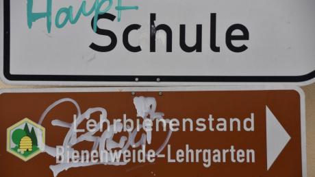 Schmierereien an der Fassade des alten Bahnhofs sowie an Schildern in Monheim.