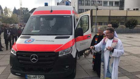 Im Rahmen der 50-Jahr-Feier segnen die evangelische Pfarrerin Kathrin Bohe und ihr katholischer Kollege Waldemar Obrebski das neue Einsatzfahrzeug der Wasserwacht Senden.