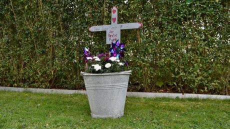Erinnerung an „den besten Papa“: ein Holzkreuz im Garten einer Familie im Landkreis Landsberg.