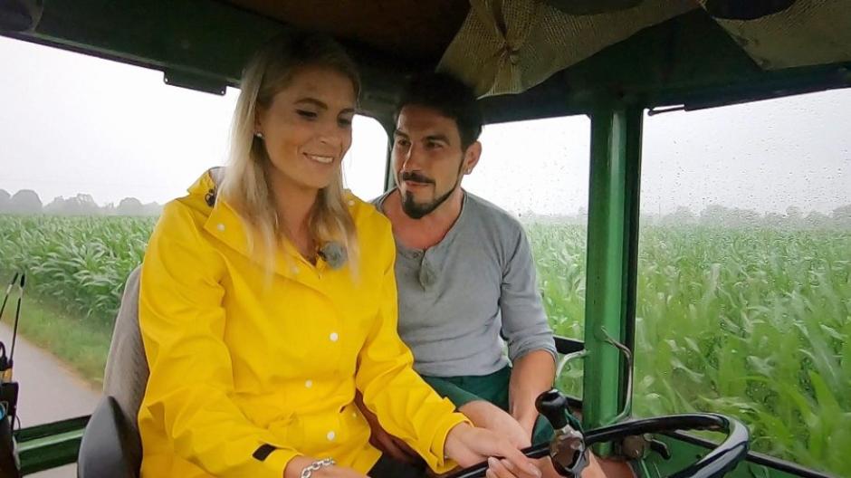 Bio-Bauer Mathias bringt Sabrina das Traktorfahren bei.