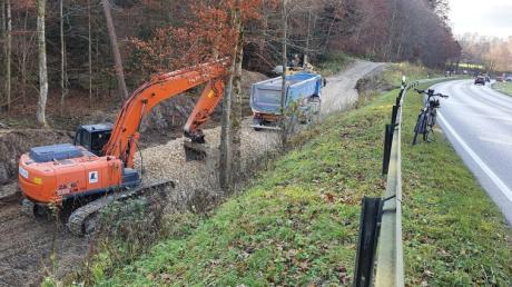 Vor kurzem haben die vorbereitenden Arbeiten zum Bau einer Radwegunterführung an der östlichen Einmündung zur B300 in Edenhausen begonnen. Baufahrzeuge befestigen den parallel zur Straße verlaufenden Forstweg und füllen die Senke vor dem geplanten Durchlass mit Schotter auf.