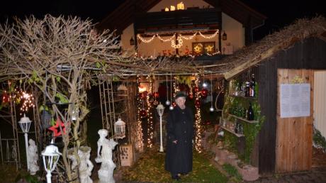 Maritta von Perbandt in ihrem Weihnachtsgarten, im Hintergrund ihr beleuchtetes Haus.