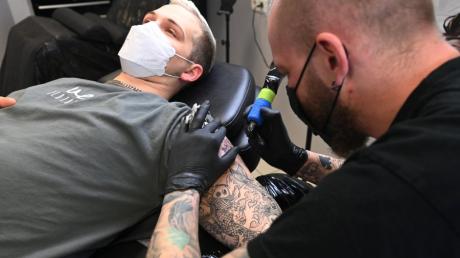 Tobias Hübenthal lässt sich von Joey Ostner ein neues Tattoo stechen. Aufgrund der neuen EU-Regelung sind die Künstler in der Auswahl ihrer Farben stark eingeschränkt.