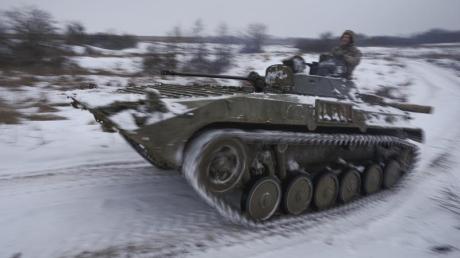 Ukrainische Soldaten fahren mit einem gepanzerten Mannschaftstransportwagen durch den Schnee.