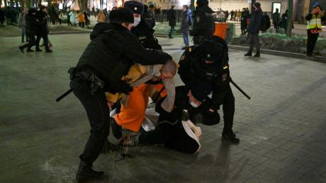 Polizisten halten Demonstranten während eines Protests gegen Russlands Angriff auf die Ukraine fest.