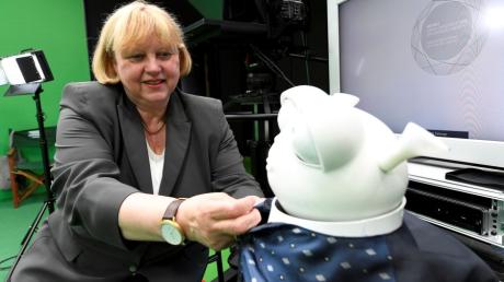 Beim Festakt für 50 Jahre Universität Augsburg präsentierte sich Präsidentin Sabine Doering-Manteuffel zukunftsorientiert mit Roboter Reeti.