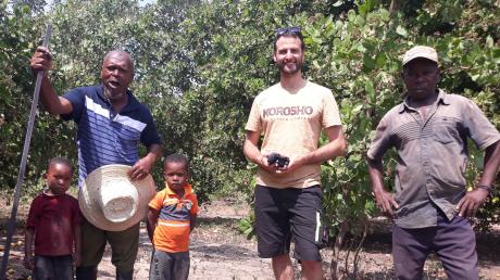 Christoph Heumos mit einem Cashew-Farmer, dessen Kindern und einem Nachbarn in Tansania.
