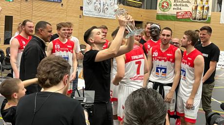 Die BG Leitershofen/Stadtbergen hat den Aufstieg in die 2. Bundesliga geschafft. Trainer Emanuel Richter reckt den Pokal in die Höhe.
