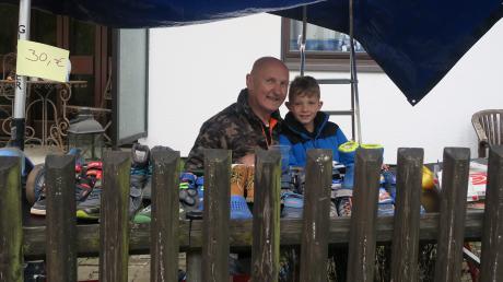 Walter Mair mit seinem Sohn Ben unter ihrem improvisierten Stand. Trotz trübem Wetter herrscht reger Betrieb auf dem Steppacher Flohmarkt.