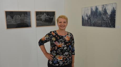 Dorothea Grathwohl, Vorsitzende des Kunstvereins Senden, steht zwischen den Werken "Fernsicht 01 und 02" von Christine Reiter (Hauptpreis) und "Wald" von Uta Weberruss (Grafiksonderpreis).