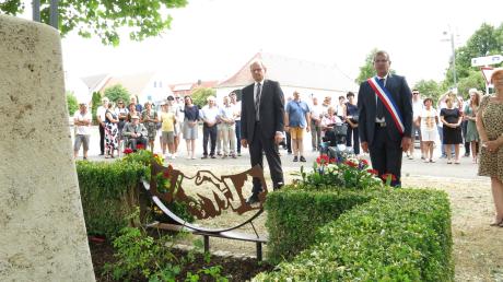 Die Bürgermeister Franz Stimpfle und Felipe Canler gedenken gemeinsam der Kriegsopfer vor den niedergelegten Blumenkränzen am Denkmal vor dem Rathaus. 