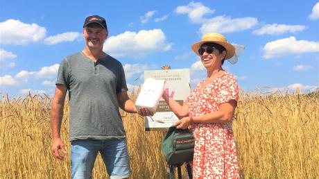 Landwirt Michael Königsberg experimentiert seit 2018 mit der alten Getreidesorte Babenhausener Rotvesen und konnte nun die erste Packung Demeter Dinkelmehl an die Bürgermeisterin Christa Bail im Rahmen der Veranstaltung am Feldrand übergeben.