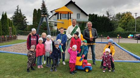 Diakon Thomas Rieger und Bürgermeister Roland Wildfeuer haben zusammen mit den Kindern den Spielplatz in Reichertswies offiziell in Betrieb genommen.