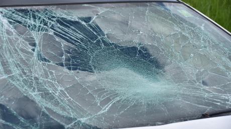 Die Windschutzscheibe eines Autos ist durch einen herabfallenden Gegenstand stark beschädigt worden.